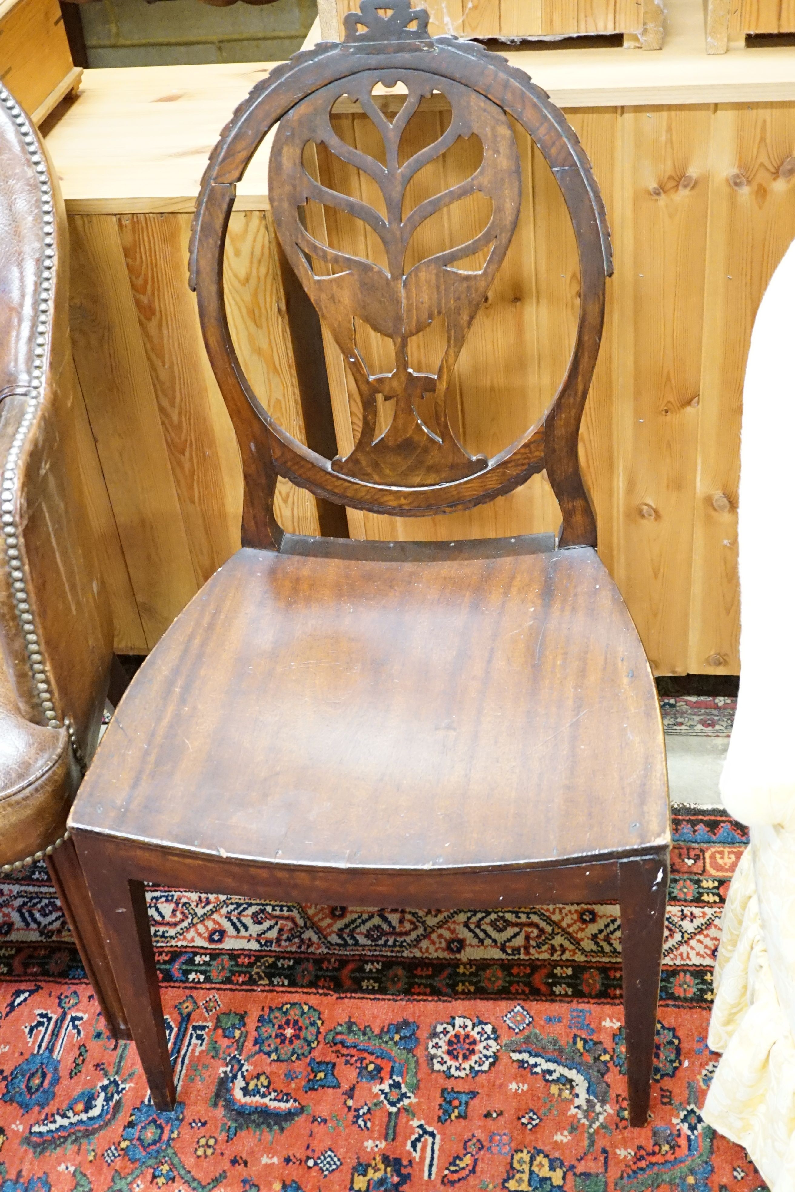 A brown leather upholstered desk chair, a mahogany hall chair and two upholstered armchairs